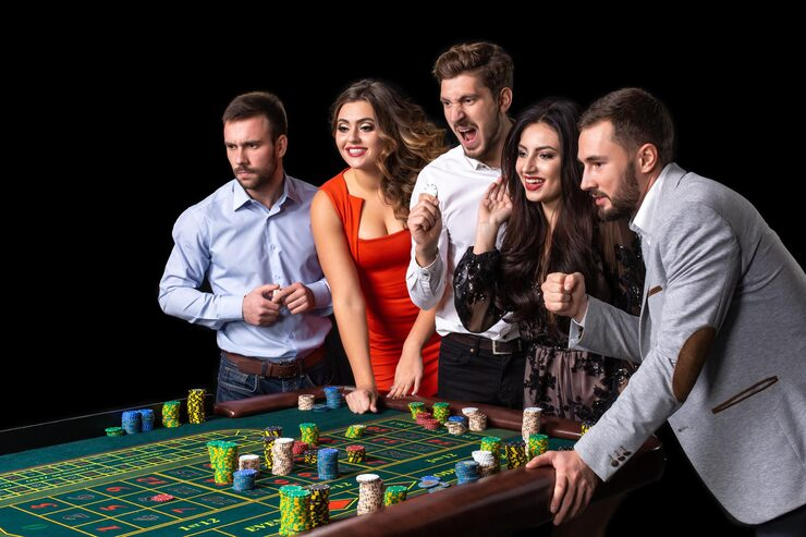 Guests in evening wear around a roulette table at a gala evening